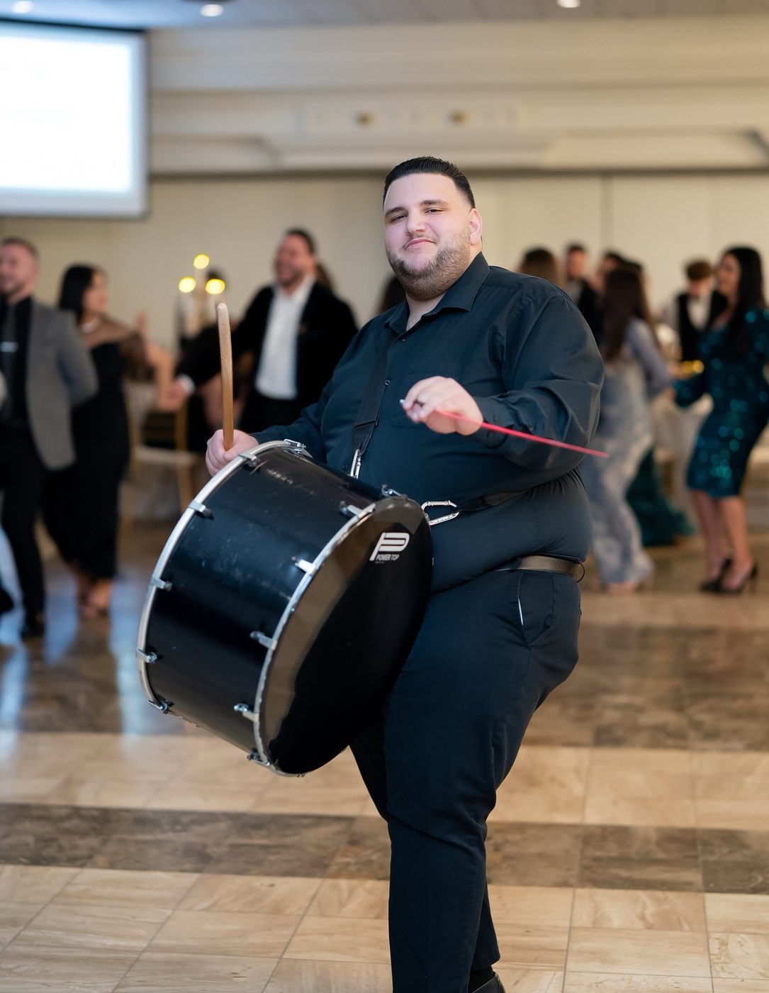 A Prestige Brothers drummer mid-step during a reception entrance