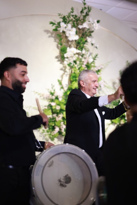 A Prestige Brothers drummer mid-strike beside the guest of honour